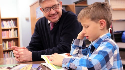 Glen Superintendent and student read a book
