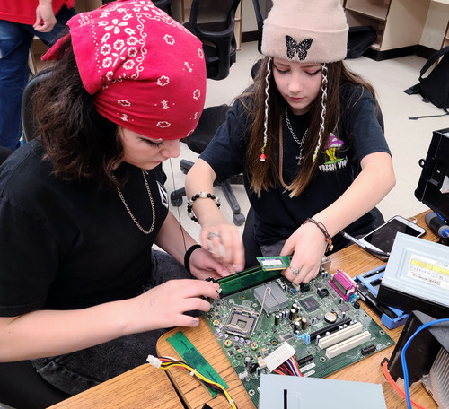 Students working on the inside of a computer