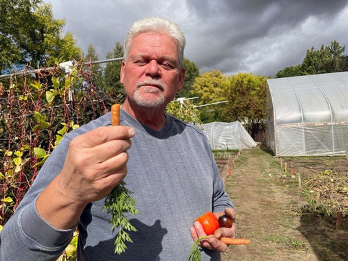 Picture of Kent Simons of Simple Gifts Farm holding a carrot